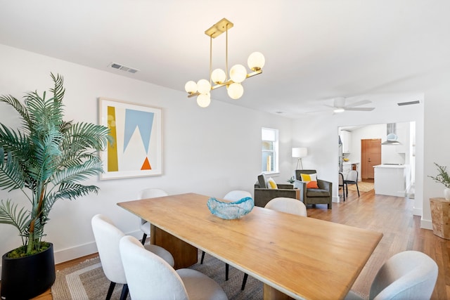 10414 Robindale Dr, Dallas, TX 75238 - dining area with ceiling fan with notable chandelier, light wood-type flooring, visible vents, and baseboards