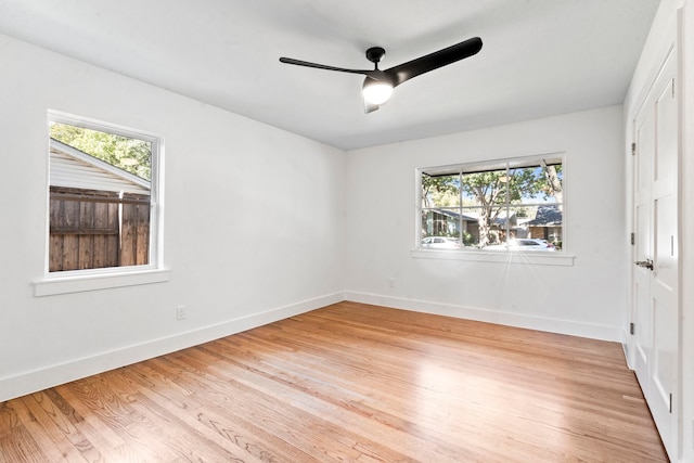 empty room featuring ceiling fan, plenty of natural light, and light hardwood / wood-style flooring