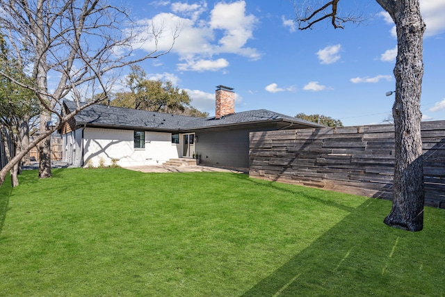 10414 Robindale Dr, Dallas, TX 75238 - back of house featuring entry steps, a patio, a fenced backyard, a lawn, and a chimney