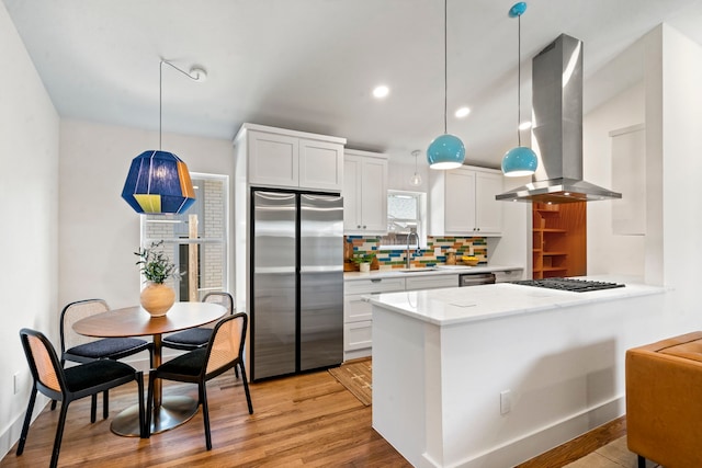 kitchen featuring white cabinetry, island range hood, and stainless steel appliances