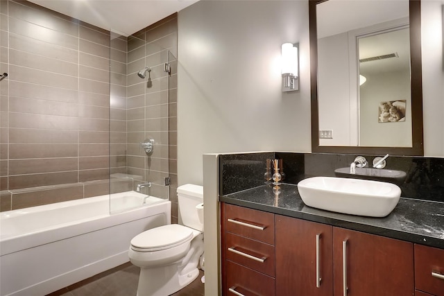 full bathroom featuring toilet, tiled shower / bath, and vanity