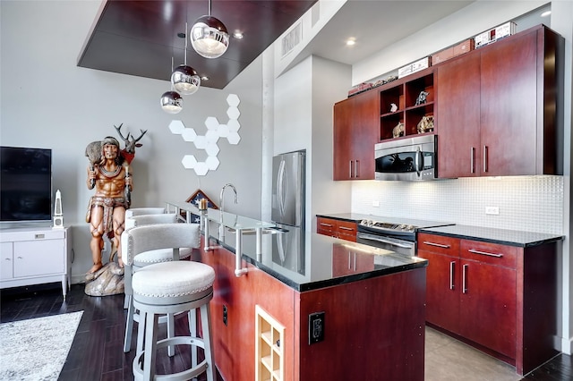 kitchen featuring a kitchen island, stainless steel appliances, tasteful backsplash, sink, and hanging light fixtures