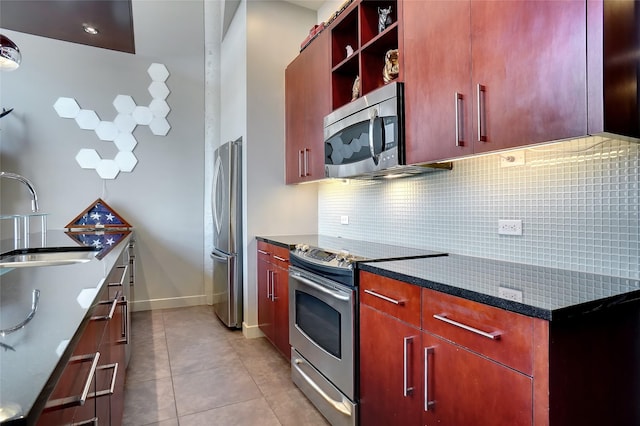 kitchen with tasteful backsplash, sink, stainless steel appliances, light tile patterned floors, and dark stone counters