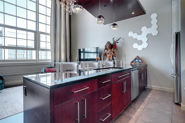 kitchen featuring stainless steel appliances, tile patterned flooring, decorative light fixtures, and sink