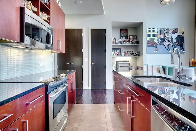 kitchen with backsplash, tile patterned floors, sink, and stainless steel appliances