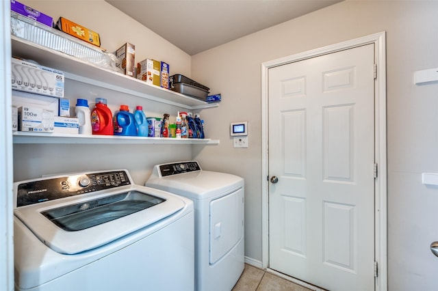 clothes washing area featuring washing machine and dryer and light tile patterned flooring