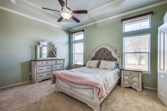 bedroom with ceiling fan, light colored carpet, crown molding, and a tray ceiling