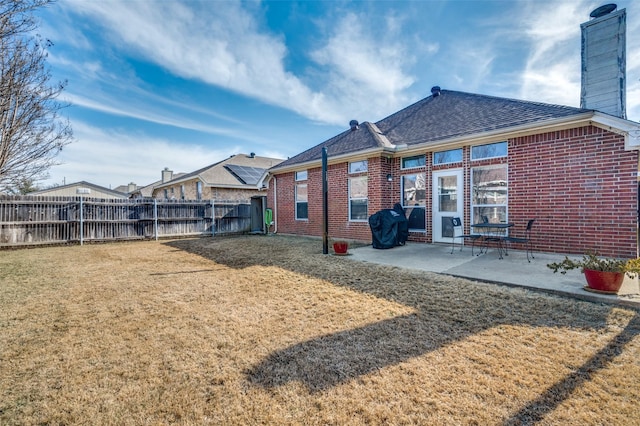 back of house featuring a patio area and a lawn