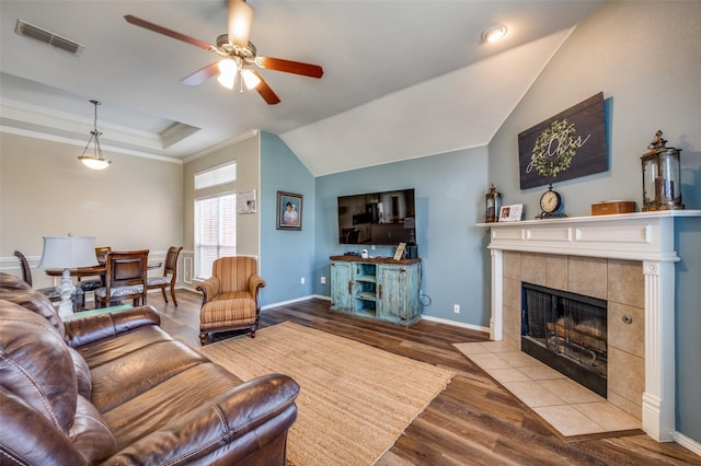 living room featuring ceiling fan, a fireplace, ornamental molding, and light hardwood / wood-style flooring