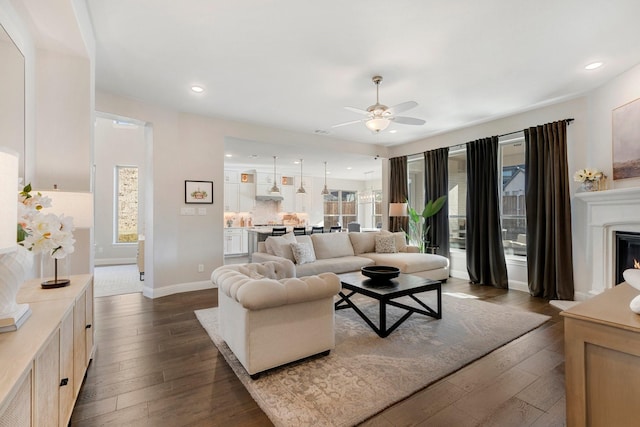 living room with dark hardwood / wood-style flooring and ceiling fan