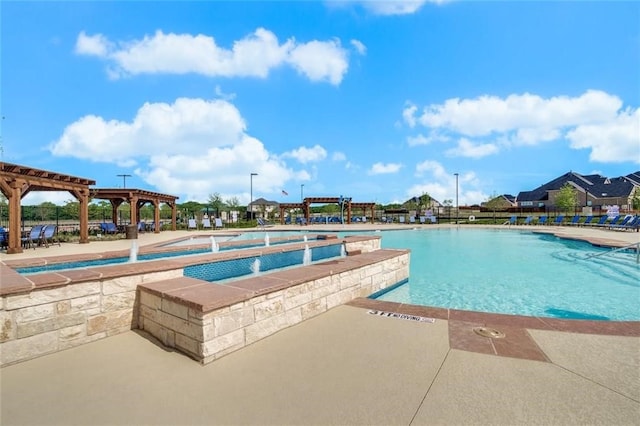 view of swimming pool with a hot tub and a patio