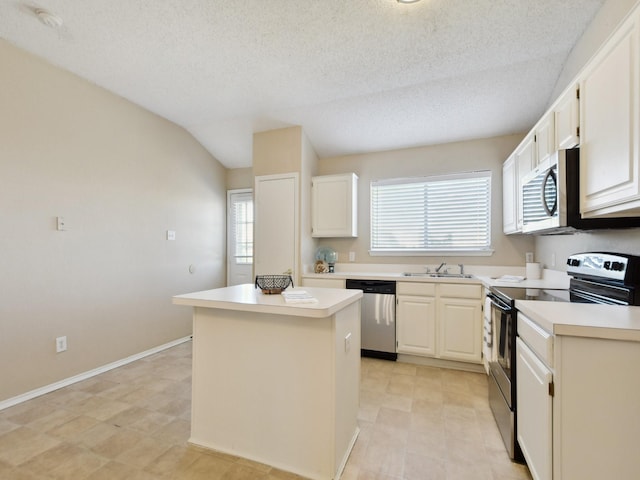 kitchen featuring vaulted ceiling, stainless steel appliances, white cabinets, and a kitchen island