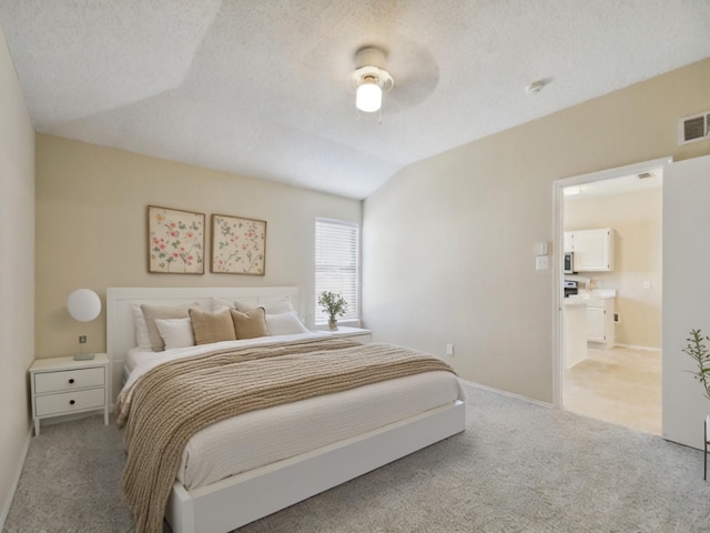 bedroom featuring vaulted ceiling, ceiling fan, a textured ceiling, and light carpet