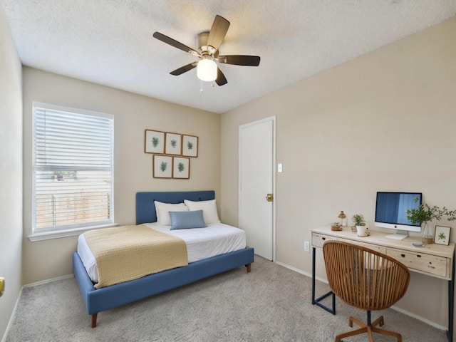 bedroom with ceiling fan, a textured ceiling, and light carpet