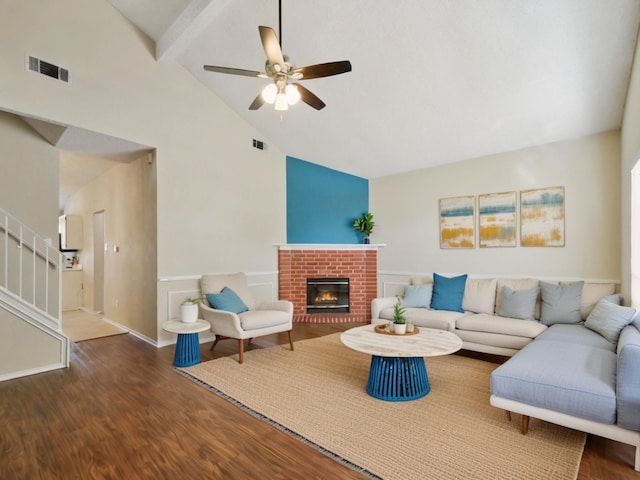 living room featuring beamed ceiling, ceiling fan, dark hardwood / wood-style floors, high vaulted ceiling, and a brick fireplace