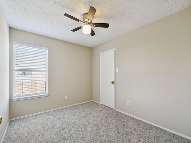 carpeted empty room featuring ceiling fan and a textured ceiling