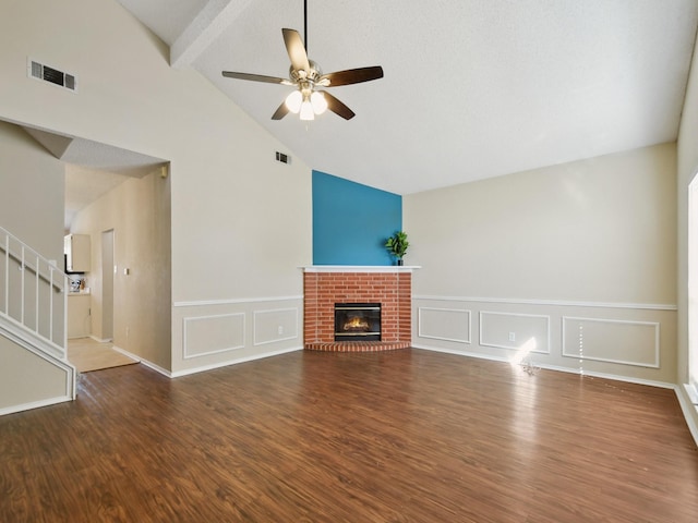 unfurnished living room with ceiling fan, dark hardwood / wood-style flooring, a fireplace, and beamed ceiling