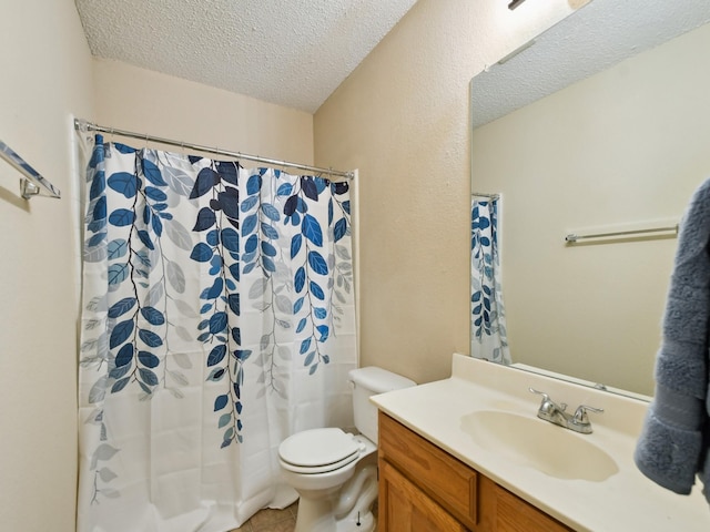 bathroom featuring a textured ceiling, toilet, walk in shower, and vanity