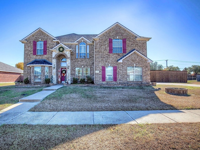 view of front property featuring a front lawn and an outdoor fire pit