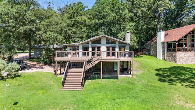 back of property with a yard and a wooden deck