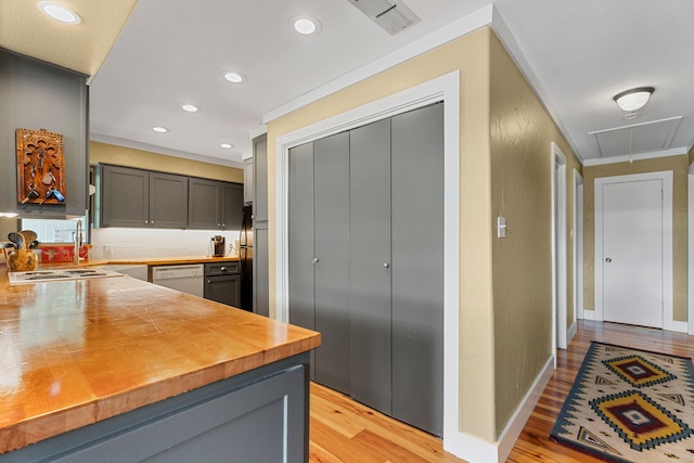 kitchen featuring dishwasher, gray cabinetry, light wood-type flooring, stainless steel gas stovetop, and crown molding