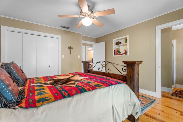 bedroom featuring ceiling fan, hardwood / wood-style flooring, a closet, and crown molding