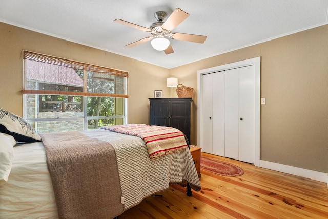 bedroom with ceiling fan, hardwood / wood-style floors, a closet, and ornamental molding