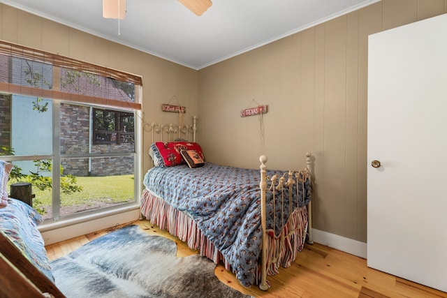 bedroom featuring ceiling fan, ornamental molding, and hardwood / wood-style floors