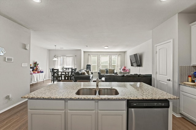 kitchen featuring dark wood-type flooring, sink, dishwasher, and a kitchen island with sink