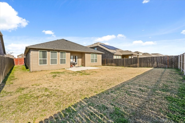 back of property with a yard and a patio