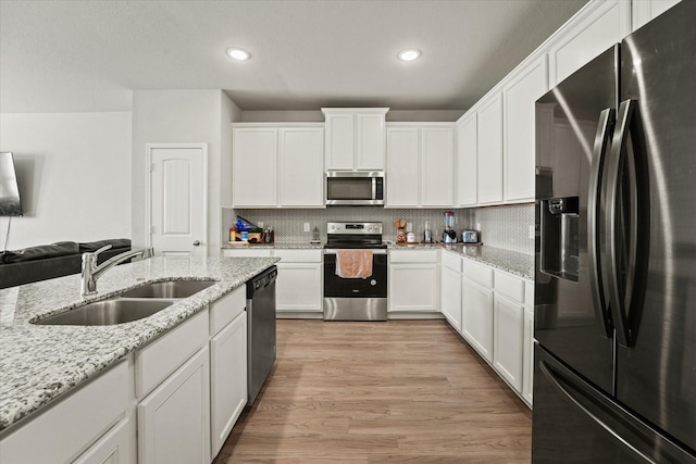 kitchen with white cabinets, backsplash, appliances with stainless steel finishes, and sink