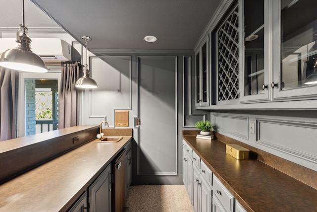 kitchen featuring hanging light fixtures, dark countertops, glass insert cabinets, and a sink