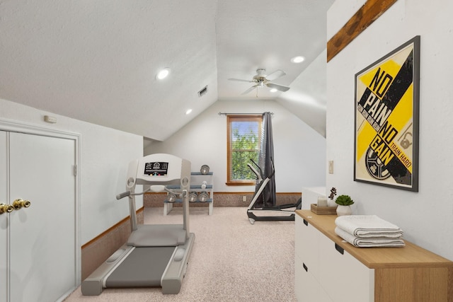 exercise room with a textured ceiling, lofted ceiling, light carpet, visible vents, and a ceiling fan