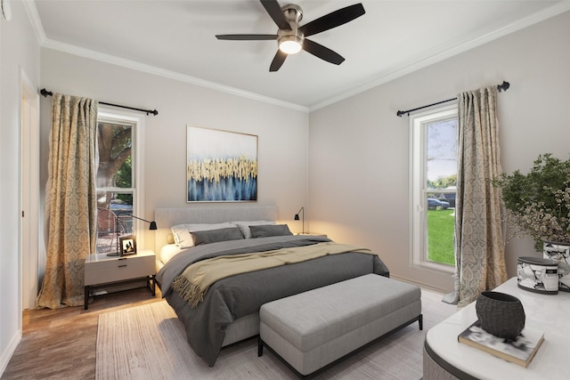 bedroom with a ceiling fan, multiple windows, ornamental molding, and wood finished floors