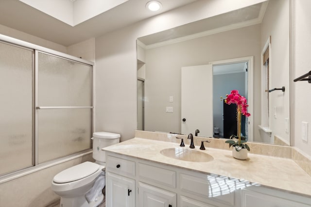 full bathroom with combined bath / shower with glass door, crown molding, vanity, and toilet