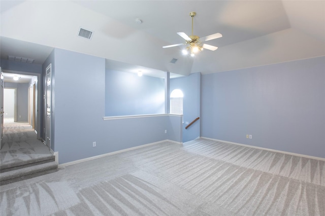 carpeted spare room with ceiling fan and lofted ceiling