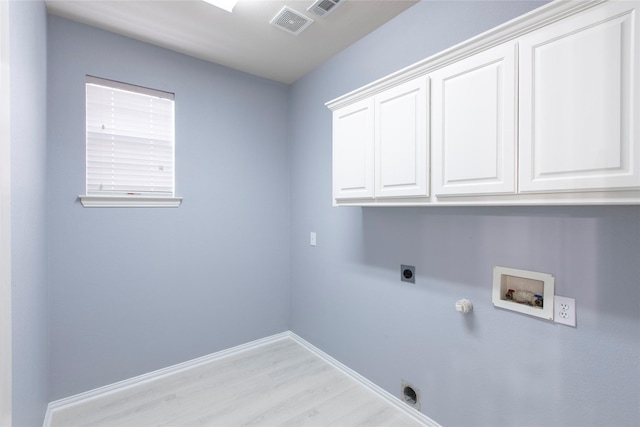 laundry area featuring hookup for a gas dryer, light hardwood / wood-style floors, hookup for a washing machine, hookup for an electric dryer, and cabinets