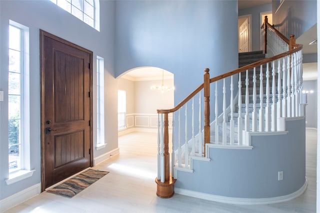 foyer entrance with ornamental molding and a notable chandelier