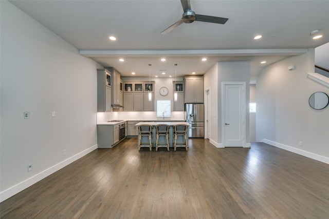 kitchen featuring appliances with stainless steel finishes, a kitchen breakfast bar, gray cabinetry, and a center island