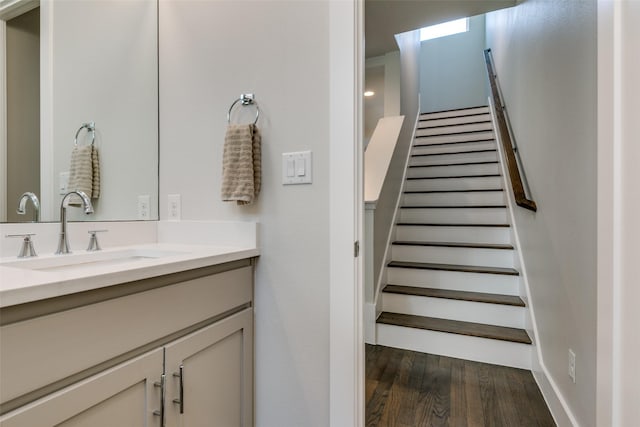 staircase featuring sink and hardwood / wood-style flooring