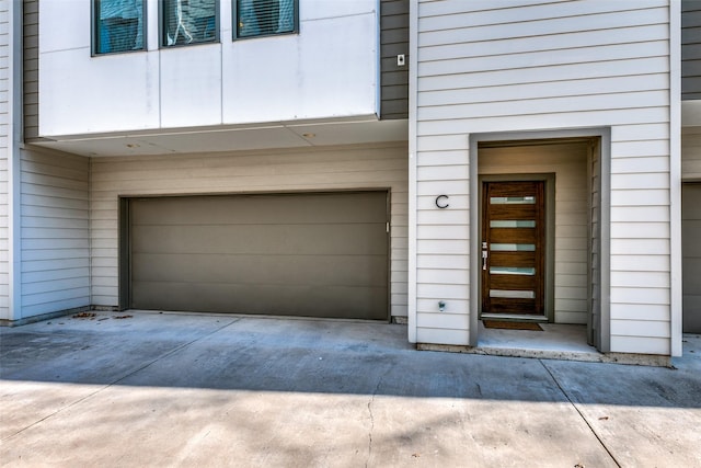 entrance to property featuring a garage and driveway