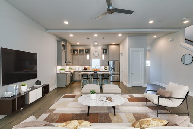 kitchen with a center island, decorative light fixtures, dark hardwood / wood-style flooring, sink, and a kitchen breakfast bar