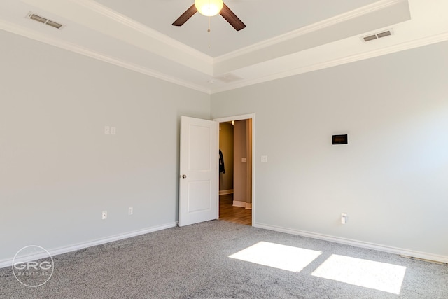 carpeted empty room featuring ceiling fan, a tray ceiling, and crown molding