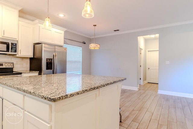 kitchen with appliances with stainless steel finishes, decorative backsplash, white cabinets, and hanging light fixtures