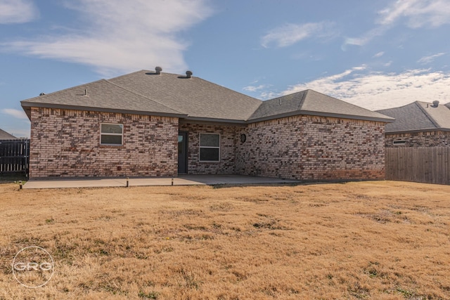 rear view of house with a lawn and a patio