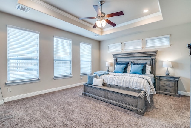 carpeted bedroom with a raised ceiling, ceiling fan, and ornamental molding