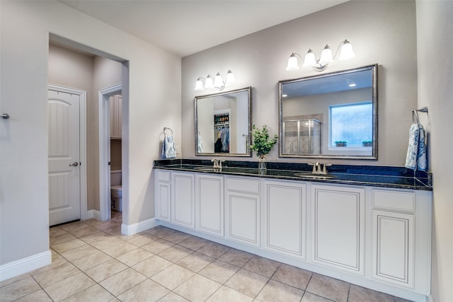 bathroom with tile patterned floors, toilet, vanity, and walk in shower