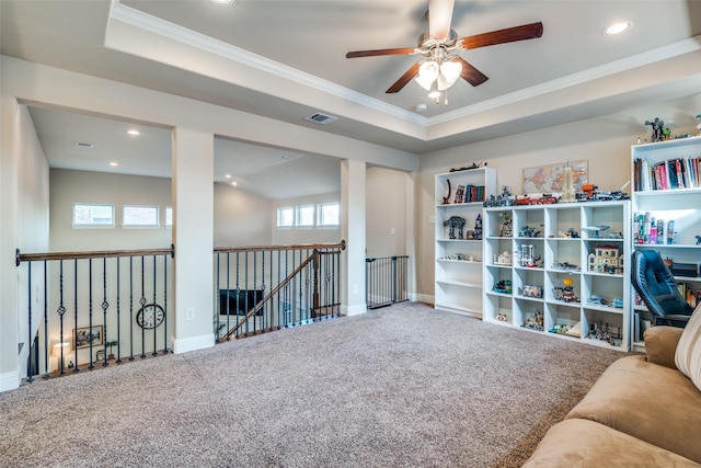 living area featuring ceiling fan, crown molding, carpet floors, and a tray ceiling