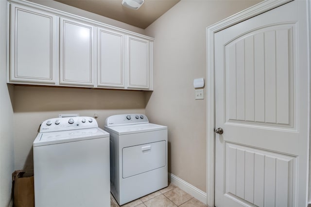 laundry area featuring cabinets, light tile patterned floors, and independent washer and dryer