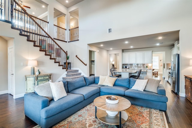 living room featuring dark hardwood / wood-style flooring and a towering ceiling